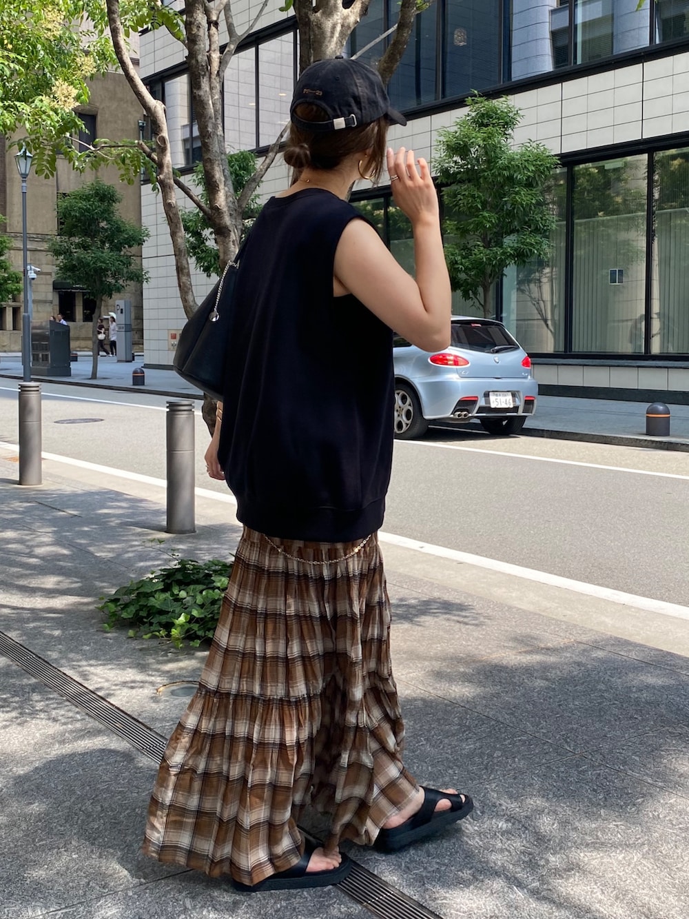 ブラック系のTシャツ/カットソー、ブラウン系のスカート、ブラック系のショルダーバッグを着用したレディースの夏コーディネートの5枚目の写真