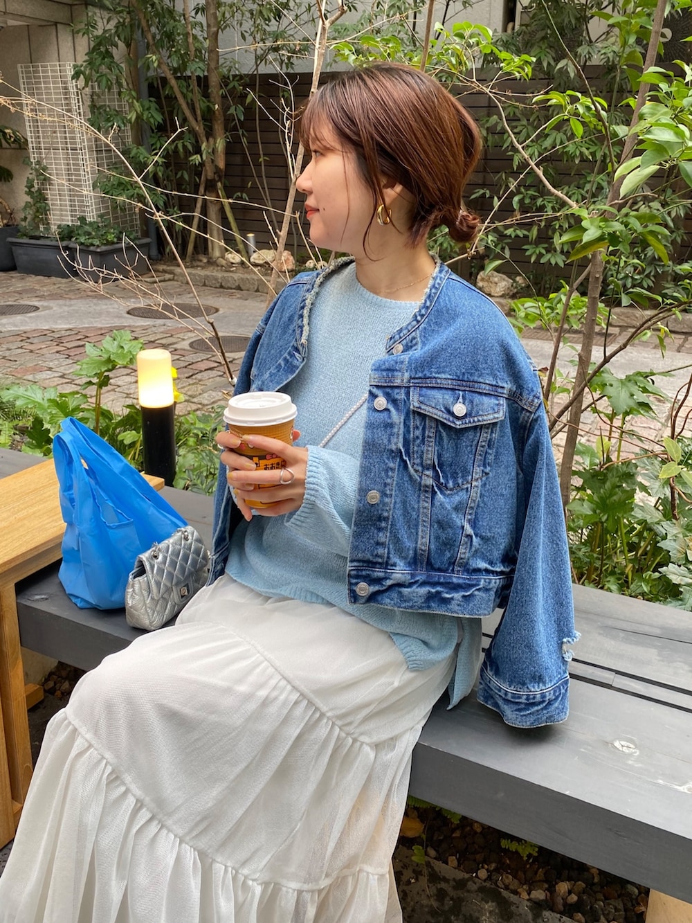 ブルー系のデニムジャケット、グレー系のニット/セーター、ホワイト系のTシャツ/カットソーを着用したレディースの春コーディネートの4枚目の写真
