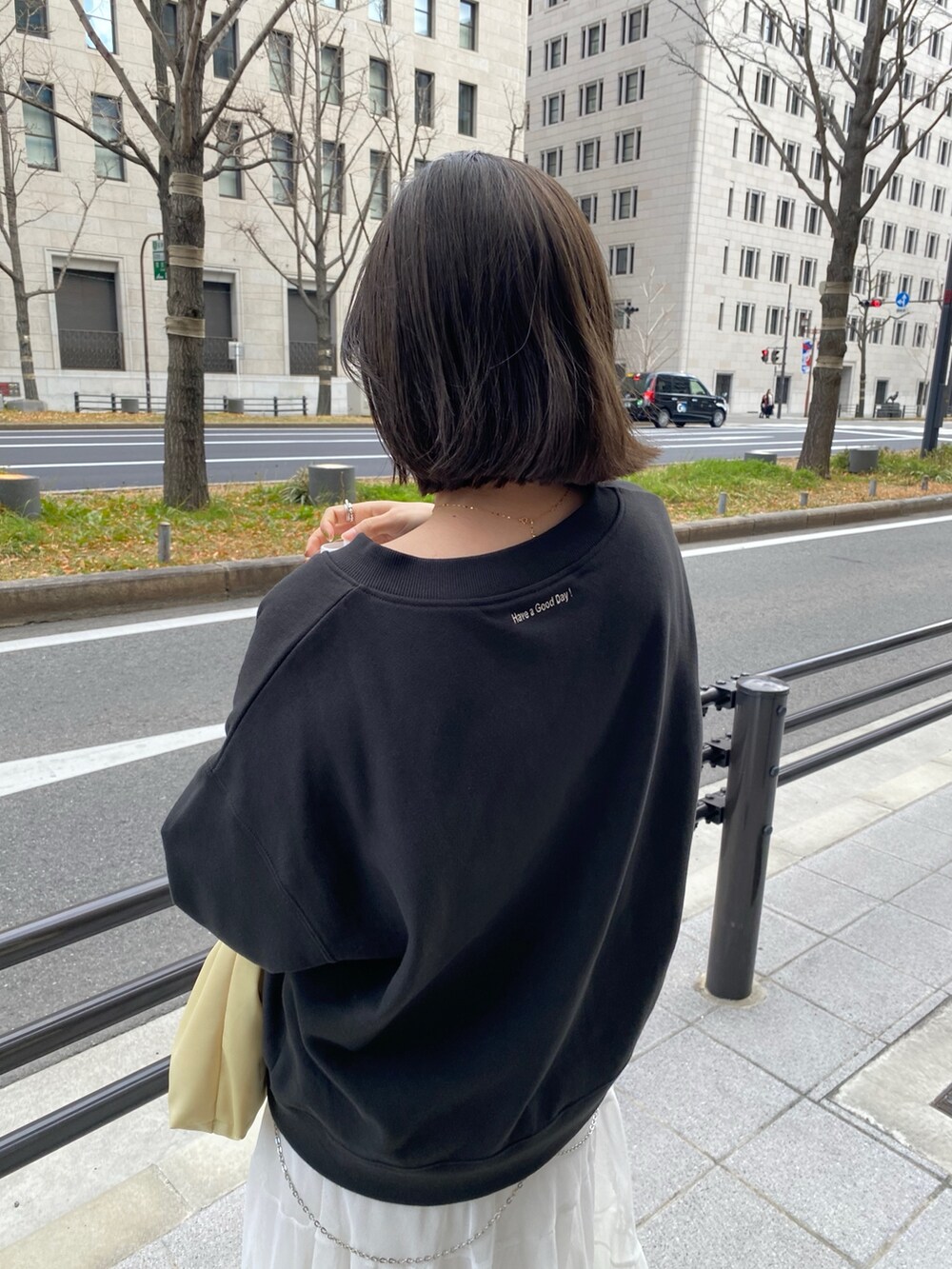 ブラック系のその他アウター、ホワイト系のスカート、イエロー系のショルダーバッグを着用したレディースの春コーディネートの8枚目の写真