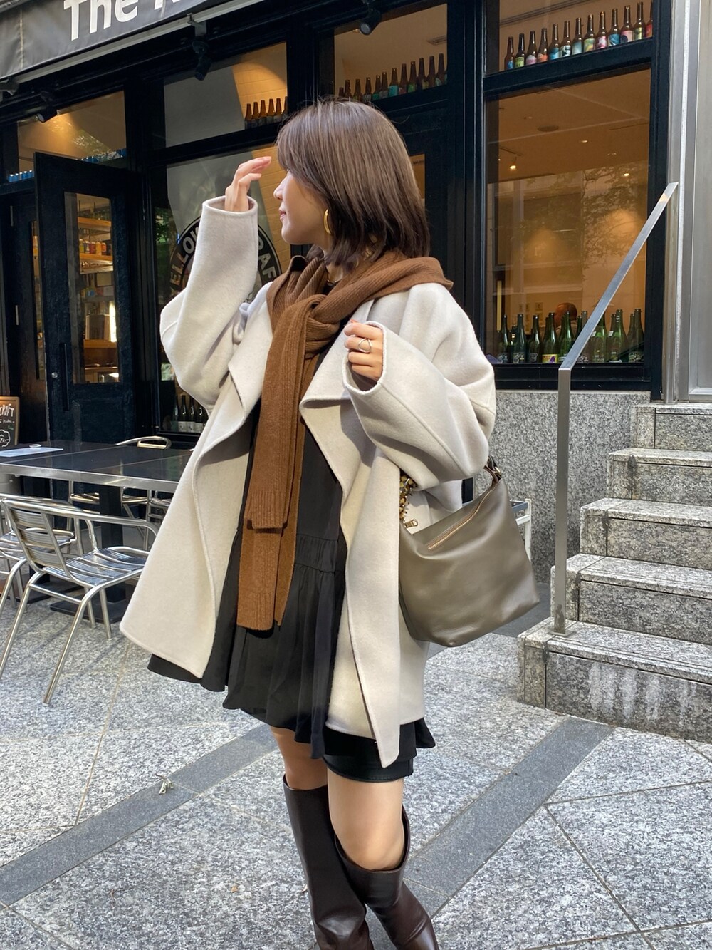 ブラック系のシャツ/ブラウス、ブラウン系のブーツ、ブラウン系のショルダーバッグを着用したレディースの秋コーディネートの2枚目の写真