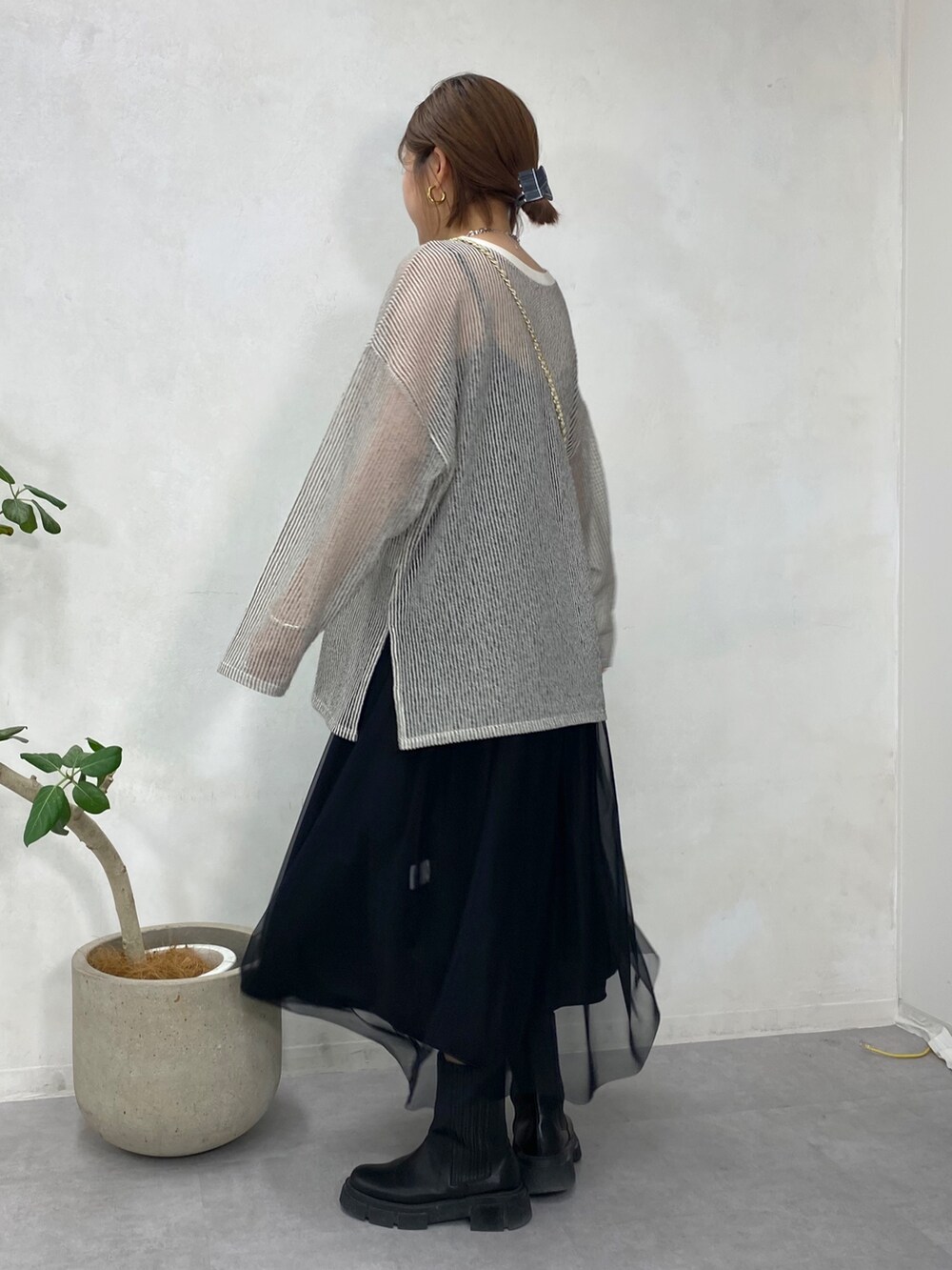 ブラック系のTシャツ/カットソー、ホワイト系のショルダーバッグ、ブラック系のスカートを着用したレディースの冬コーディネートの2枚目の写真