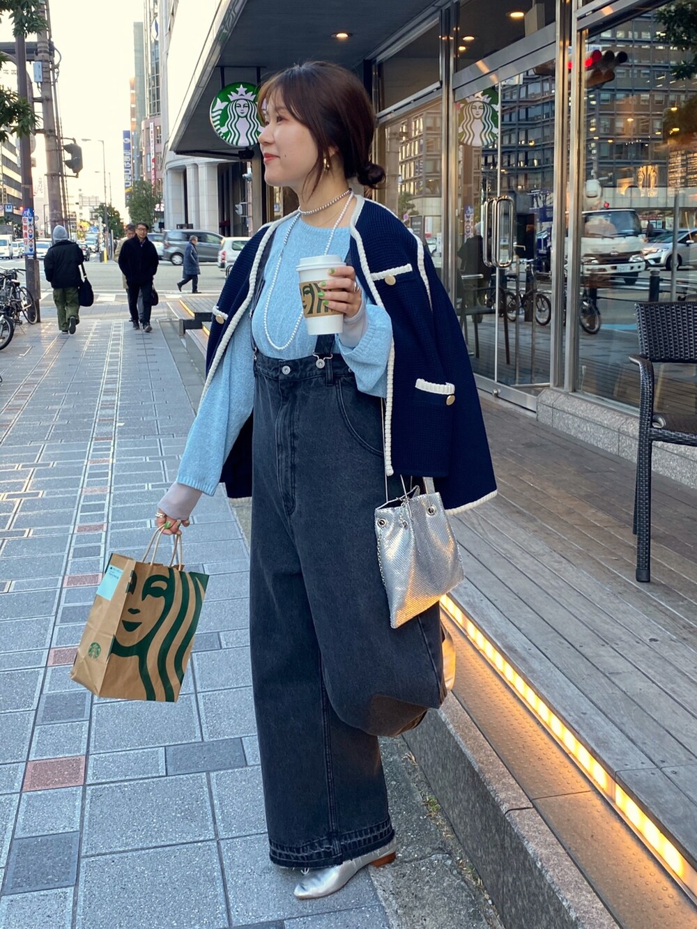 ブルー系のノーカラージャケット、ブラック系のサロペット/オーバーオール、ゴールド系のショルダーバッグを着用したレディースの冬コーディネートの6枚目の写真