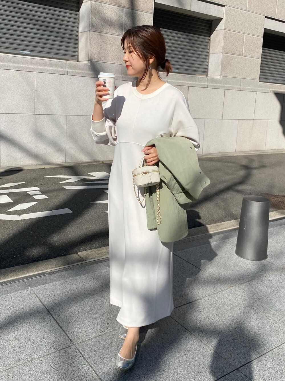 ホワイト系のワンピース、ブラック系のショルダーバッグを着用したレディースの春コーディネートの2枚目の写真