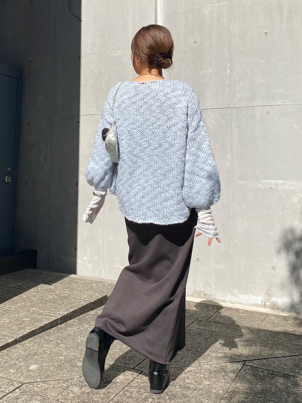 ブルー系のニット/セーター、ブルー系のTシャツ/カットソー、グレー系のムートンコートを着用したレディースの冬コーディネートの8枚目の写真