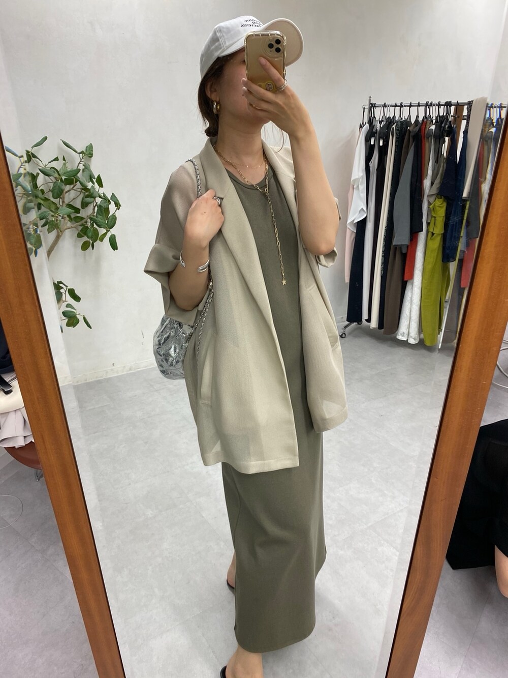 ベージュ系のテーラードジャケット、グリーン系のワンピース、シルバー系のショルダーバッグを着用したレディースの春コーディネートの2枚目の写真