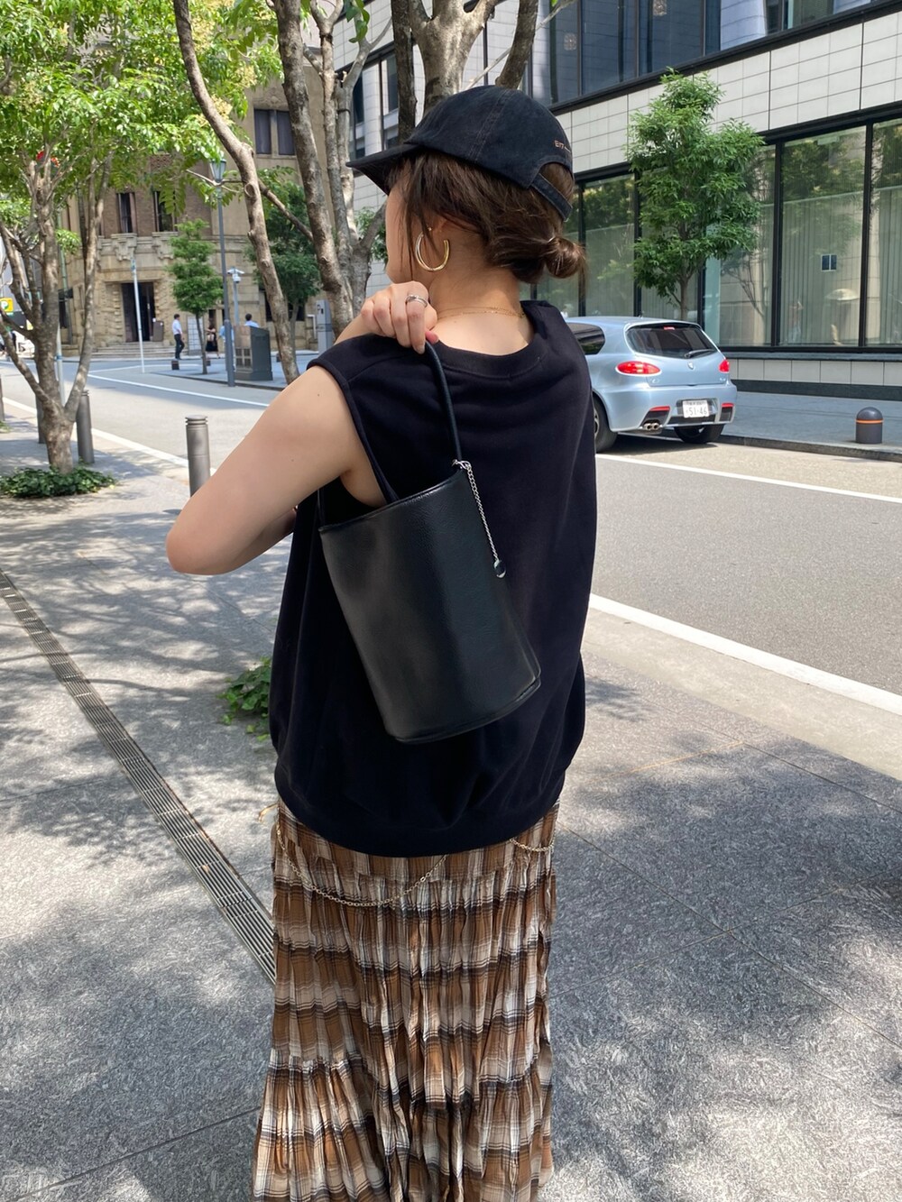 ブラック系のTシャツ/カットソー、ブラウン系のスカート、ブラック系のショルダーバッグを着用したレディースの夏コーディネートの6枚目の写真
