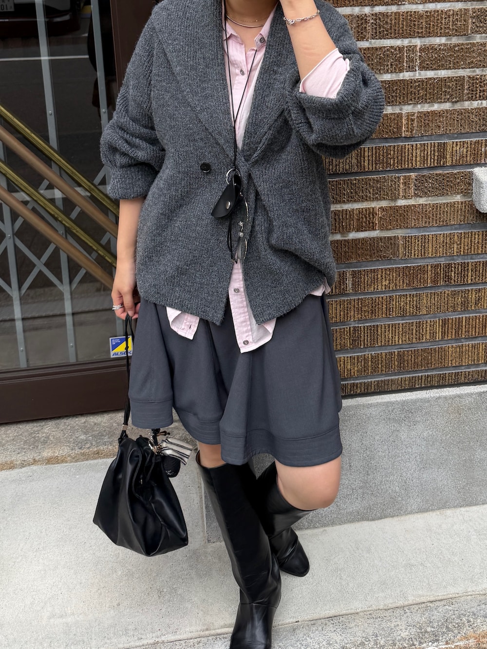 グレー系のテーラードジャケット、ピンク系のシャツ/ブラウス、グレー系のスカートを着用したレディースの秋コーディネートの3枚目の写真