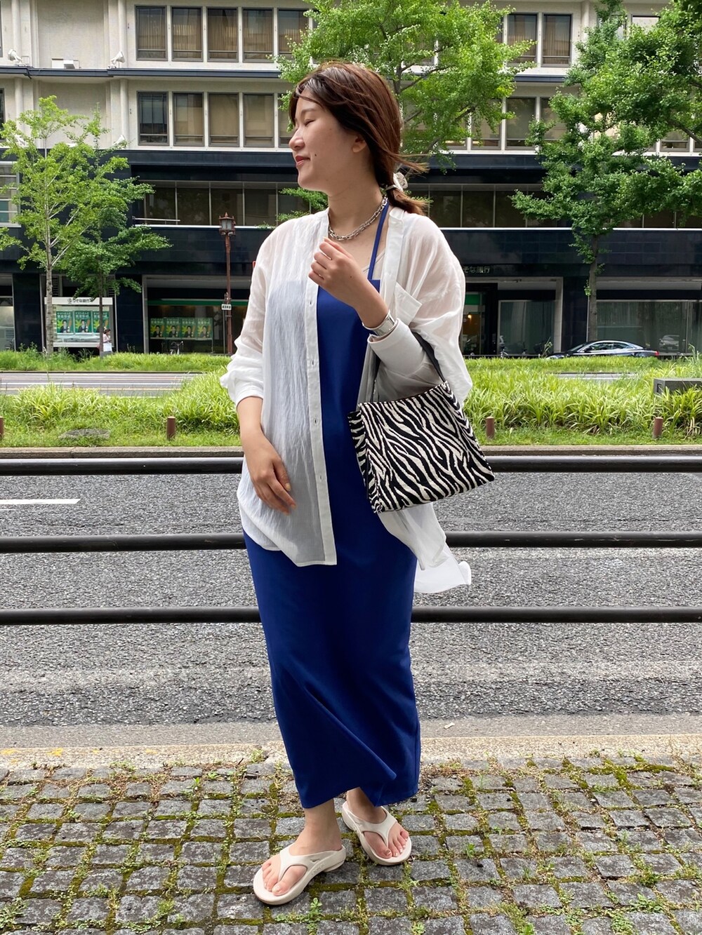 ブルー系のワンピース、ホワイト系のシャツ/ブラウス、ホワイト系のサンダルを着用したレディースの夏コーディネートの3枚目の写真