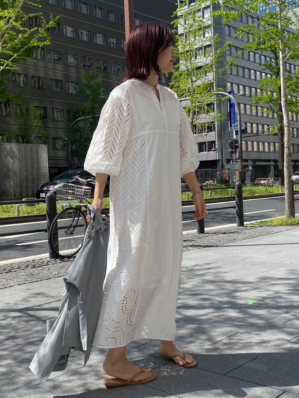 グレー系のテーラードジャケット、ホワイト系のワンピース/ドレス、シルバー系のショルダーバッグを着用したレディースの春コーディネートの2枚目の写真