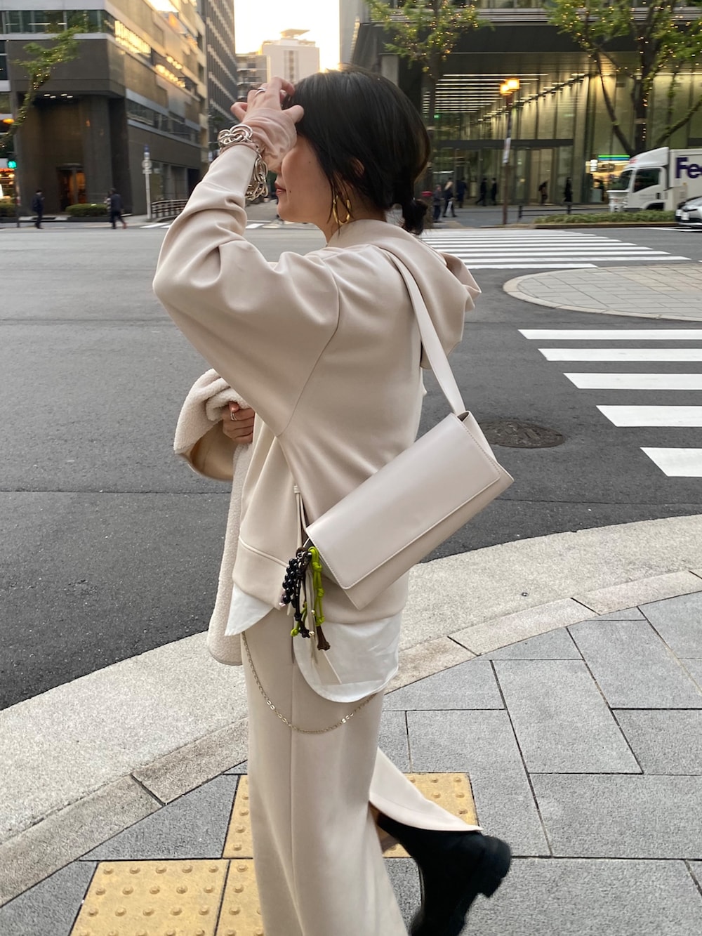 ホワイト系のセットアップ、ホワイト系のその他アウター、ホワイト系のショルダーバッグを着用したレディースの冬コーディネートの5枚目の写真
