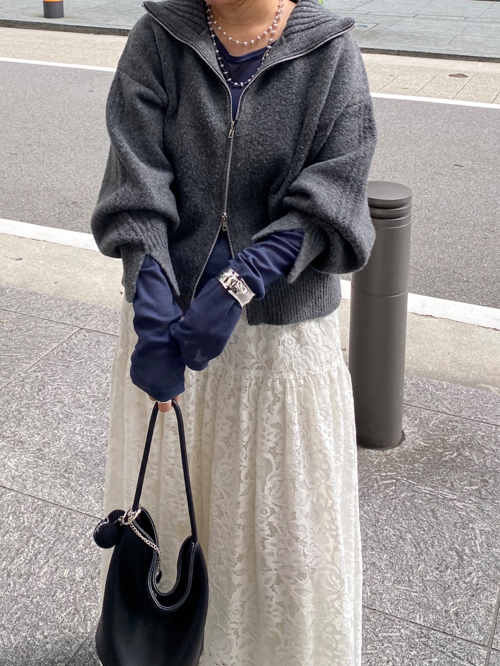 グレー系のカーディガン/ボレロ、ブルー系のTシャツ/カットソー、ホワイト系のスカートを着用したレディースの秋コーディネートの7枚目の写真