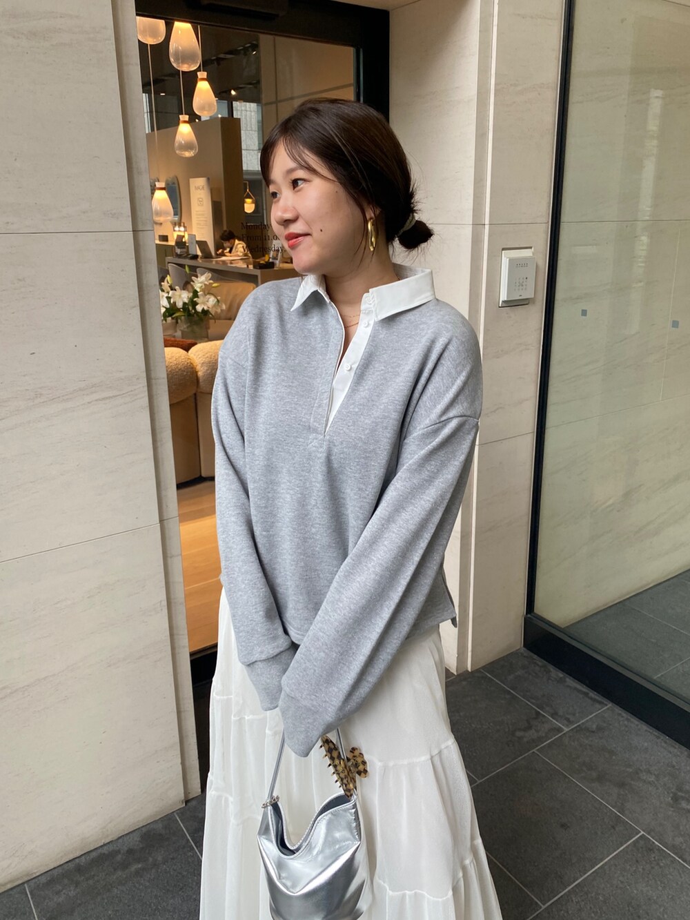 グレー系のTシャツ/カットソー、ホワイト系のスカート、シルバー系のショルダーバッグを着用したレディースの夏コーディネートの7枚目の写真