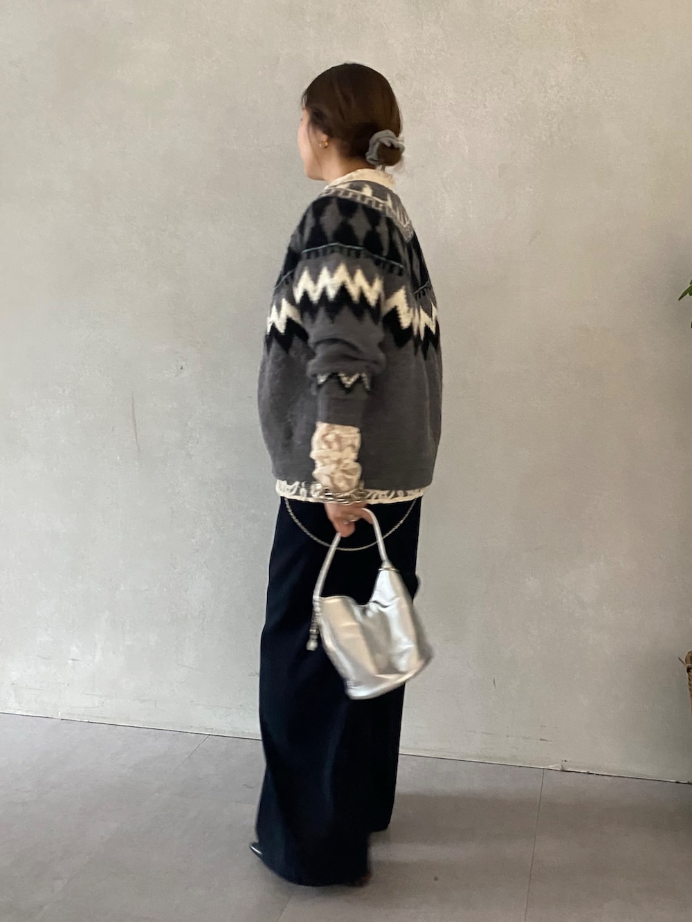 グレー系のカーディガン/ボレロ、ホワイト系のシャツ/ブラウス、ブルー系のスラックスを着用したレディースの冬コーディネートの2枚目の写真