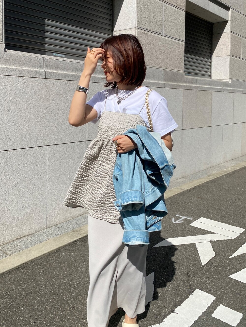 グレー系のキャミソール、ベージュ系のスカート、ブルー系のジャケット/アウターを着用したレディースの春コーディネートの3枚目の写真