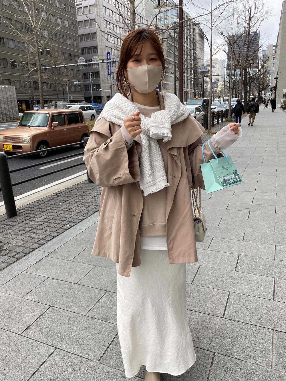 ベージュ系のジャケット/アウター、ホワイト系のスカート、ベージュ系のサンダルを着用したレディースの春コーディネートの2枚目の写真