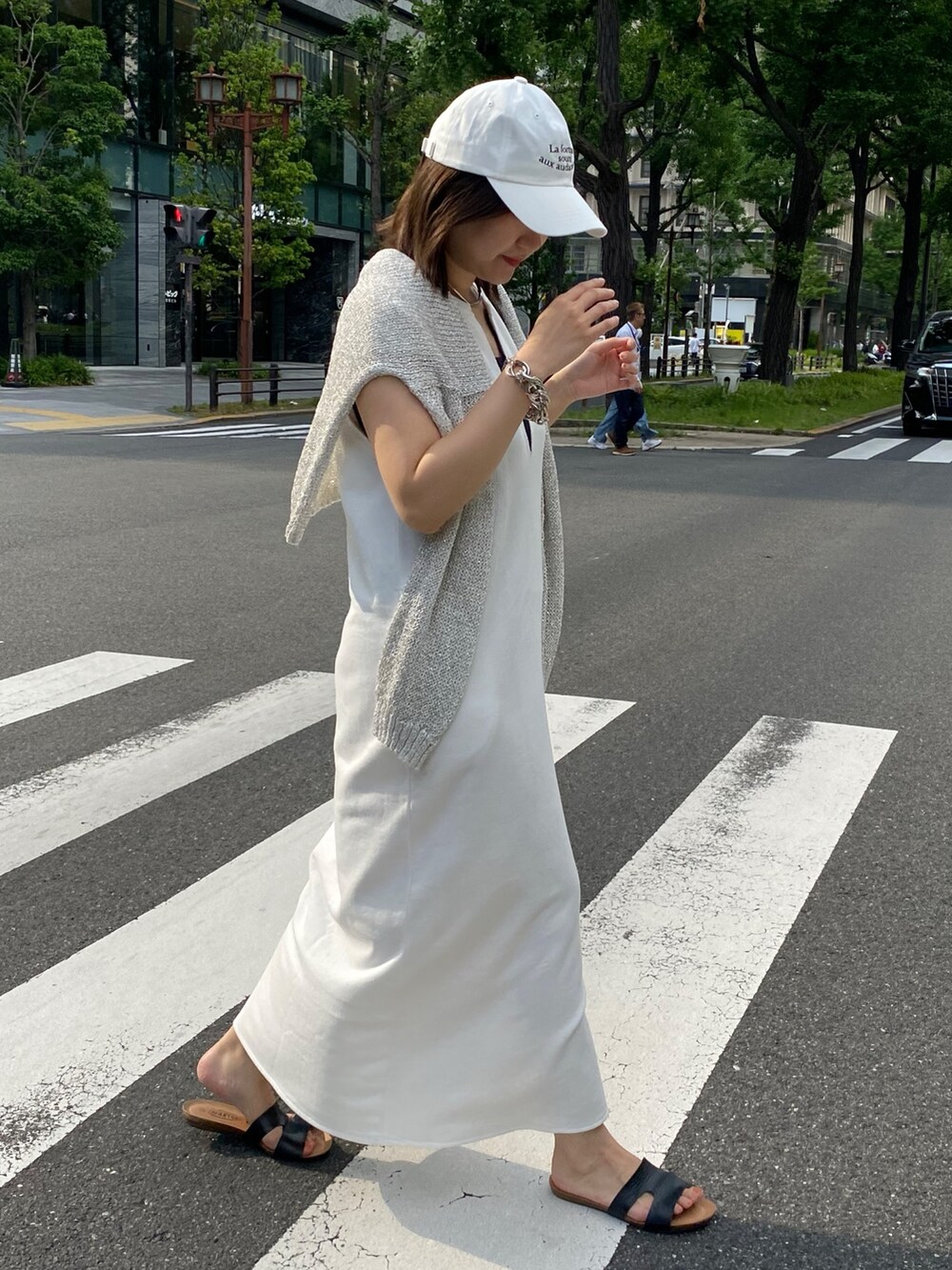 ホワイト系のワンピース、ホワイト系のキャップ、ホワイト系のネックレスを着用したレディースの夏コーディネートの5枚目の写真
