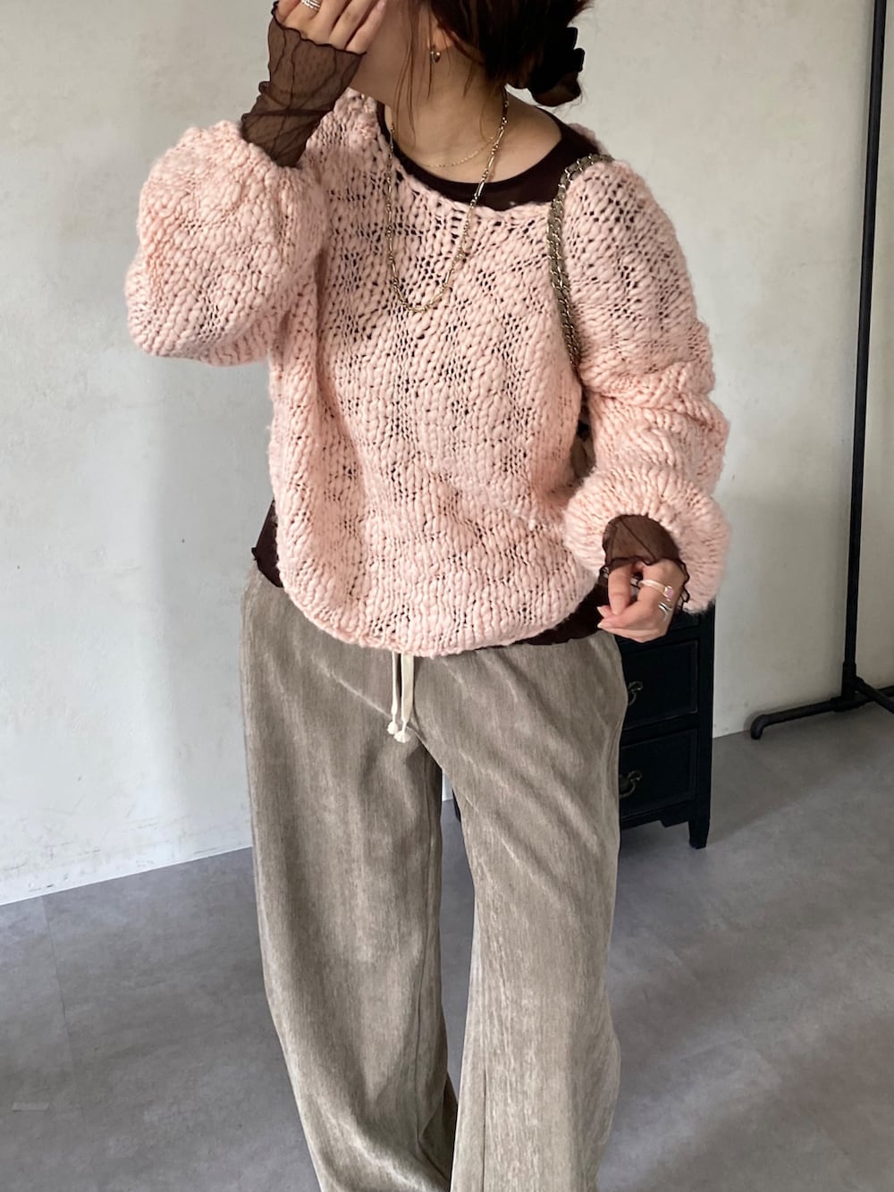 ピンク系のニット/セーター、ブラウン系のTシャツ/カットソー、ベージュ系のその他パンツを着用したレディースの冬コーディネートの6枚目の写真