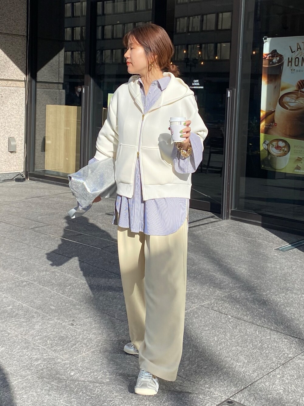 ホワイト系のパーカー、ブラック系のシャツ/ブラウス、イエロー系のスラックスを着用したレディースの冬コーディネートの2枚目の写真