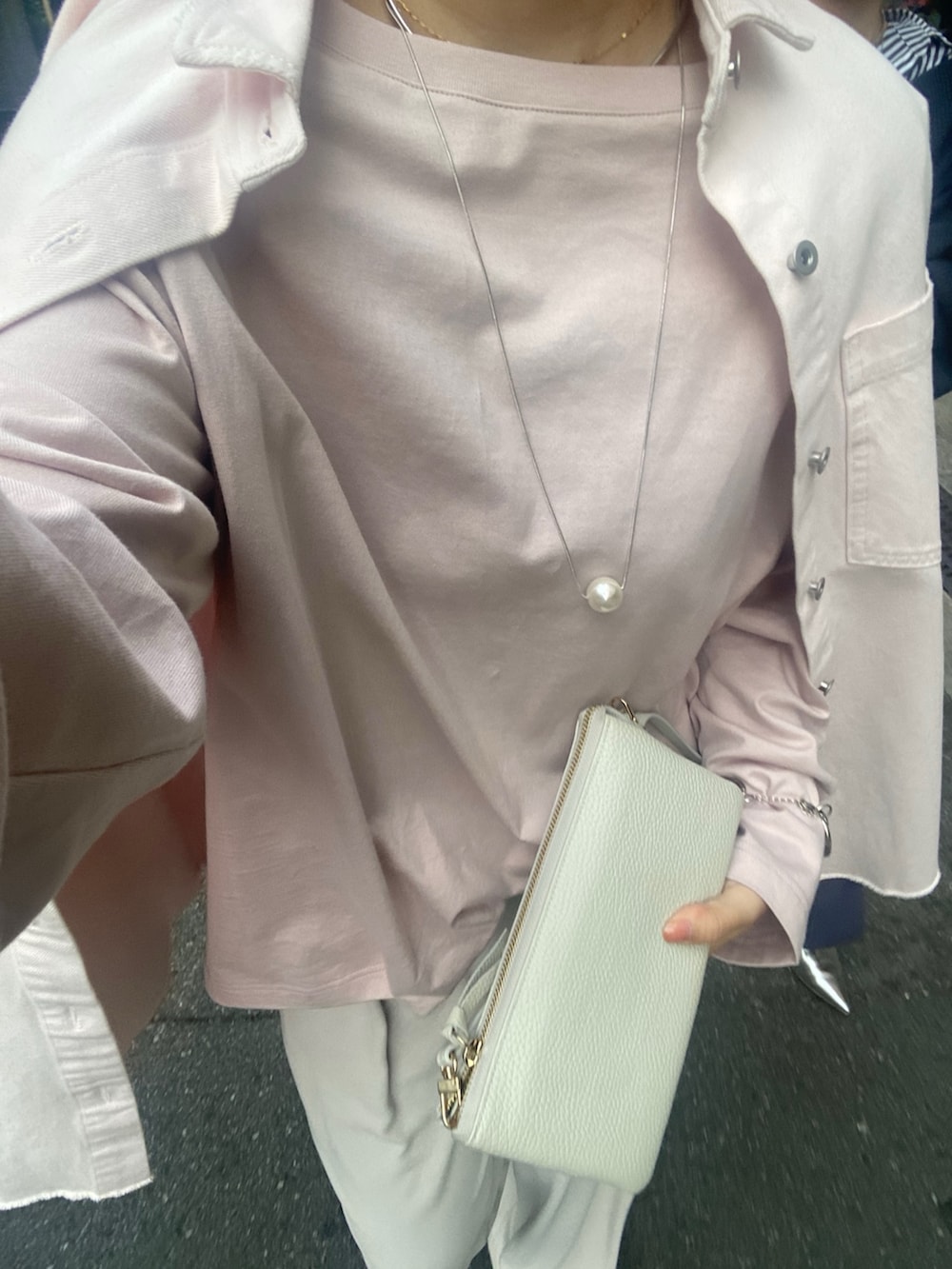 ピンク系のシャツ/ブラウス、ピンク系のTシャツ/カットソー、グレー系のスラックスを着用したレディースの冬コーディネートの9枚目の写真