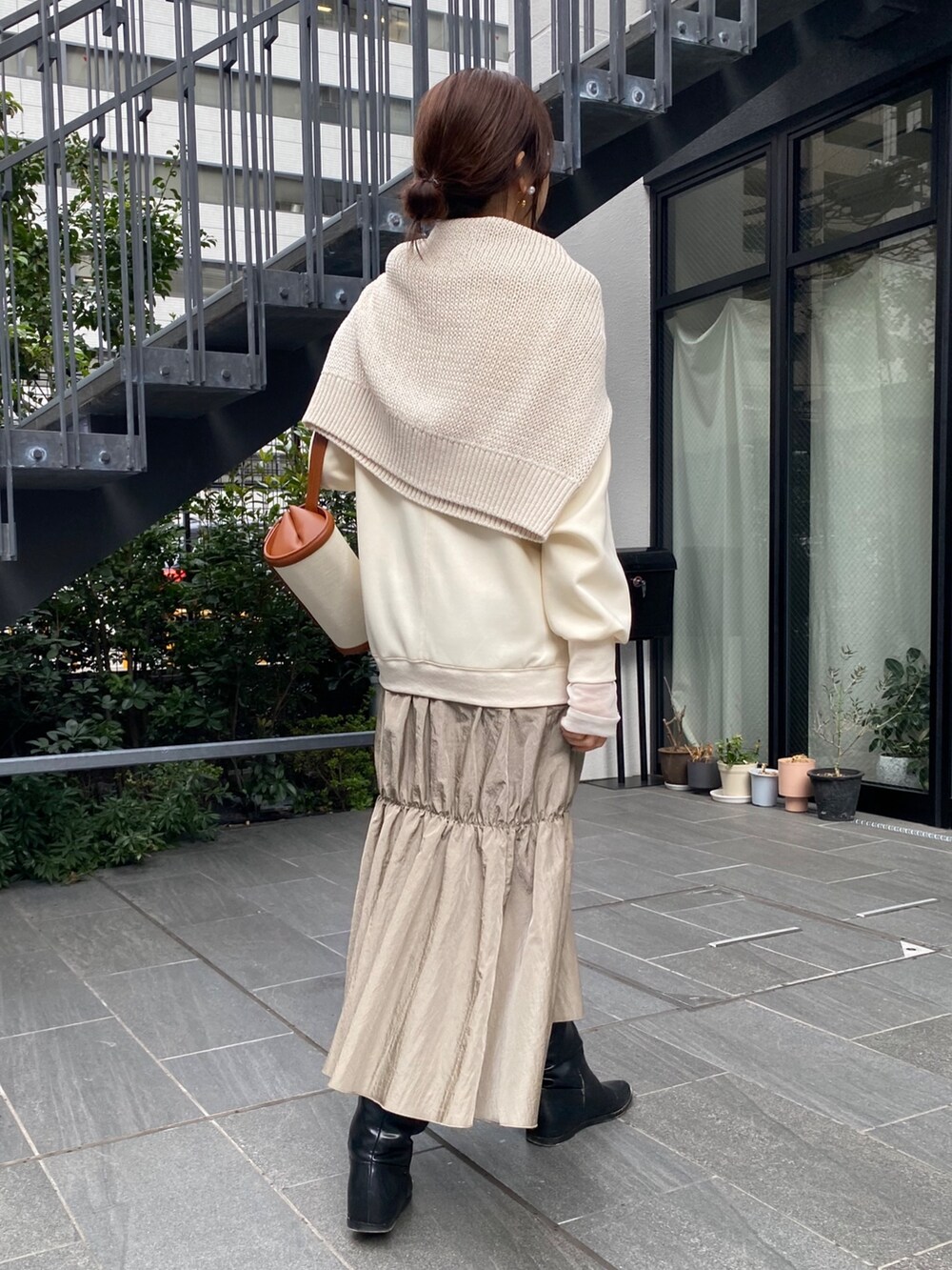 ホワイト系のワンピース、ブラック系のブーツ、シルバー系のネックレスを着用したレディースの冬コーディネートの8枚目の写真