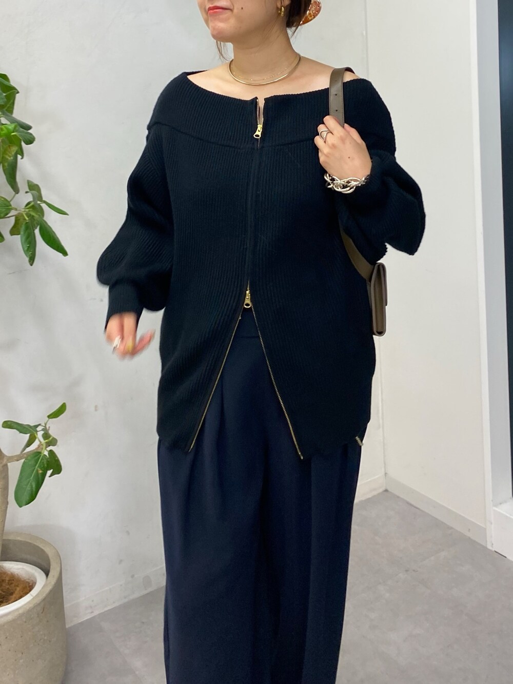 ブラック系のニット/セーター、ブルー系のスラックス、ゴールド系のサスペンダーを着用したレディースの秋コーディネートの6枚目の写真