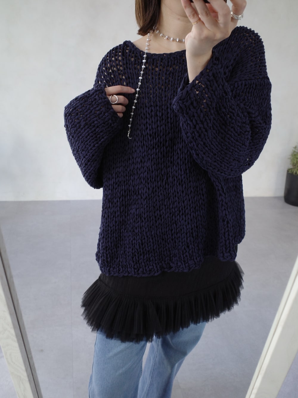 ブルー系のニット/セーター、ブラック系のシャツ/ブラウス、ブルー系のデニムパンツを着用したレディースの春コーディネートの10枚目の写真