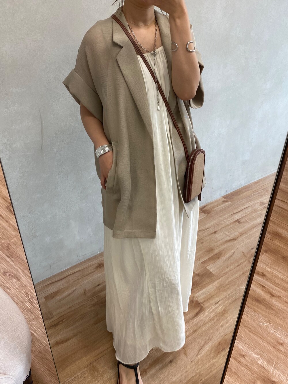 グレー系のテーラードジャケット、ホワイト系のワンピース、ホワイト系のキャップを着用したレディースの夏コーディネートの9枚目の写真