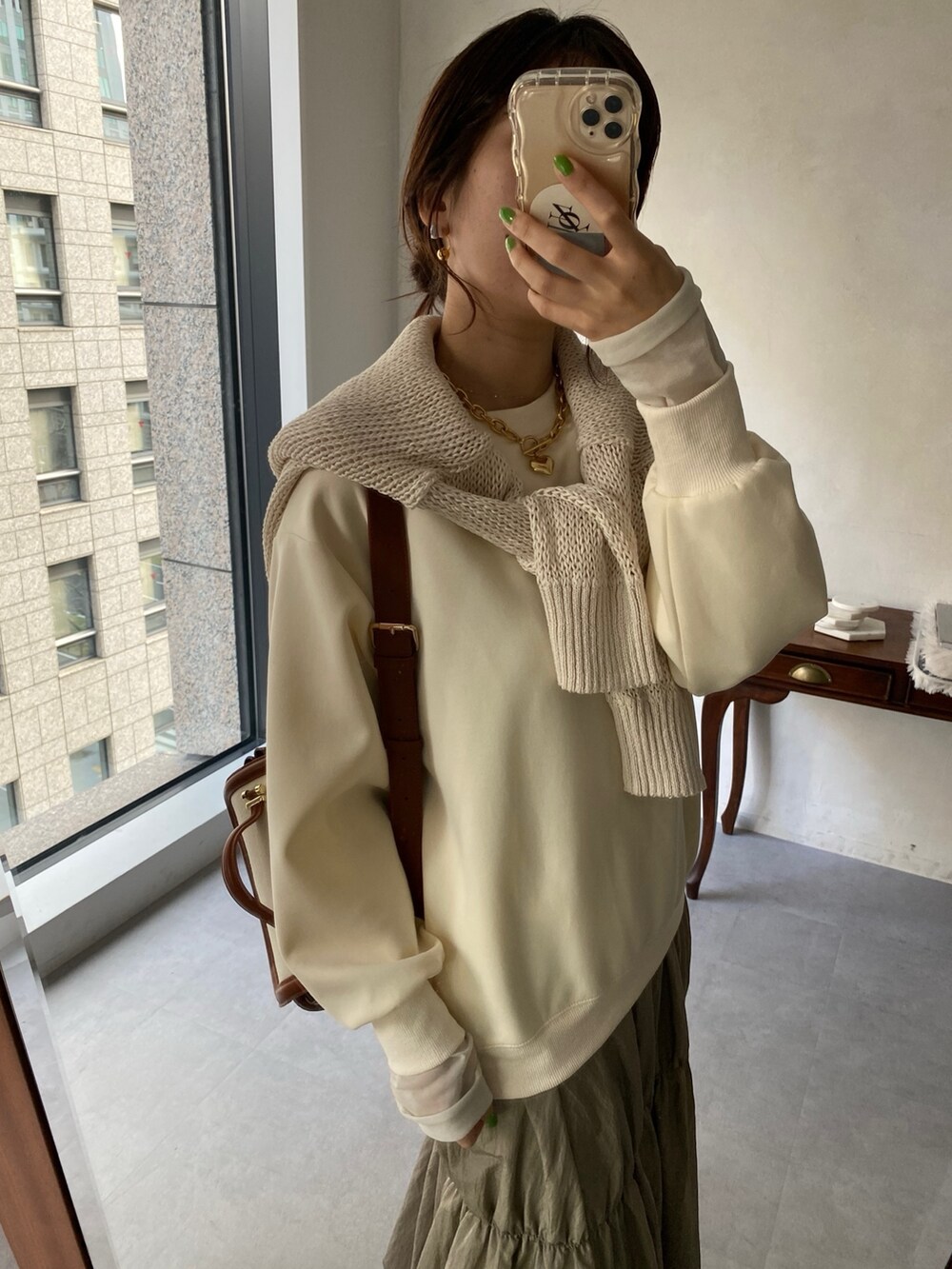 ホワイト系のワンピース、ブラック系のブーツ、シルバー系のネックレスを着用したレディースの冬コーディネートの4枚目の写真