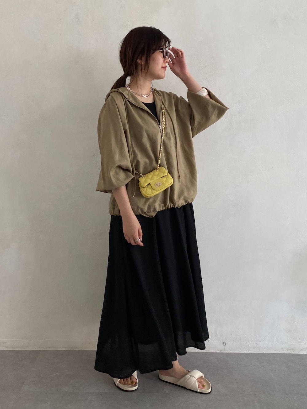 ベージュ系のシャツ/ブラウス、イエロー系のショルダーバッグ、ブラック系のワンピースを着用したレディースの夏コーディネートの5枚目の写真