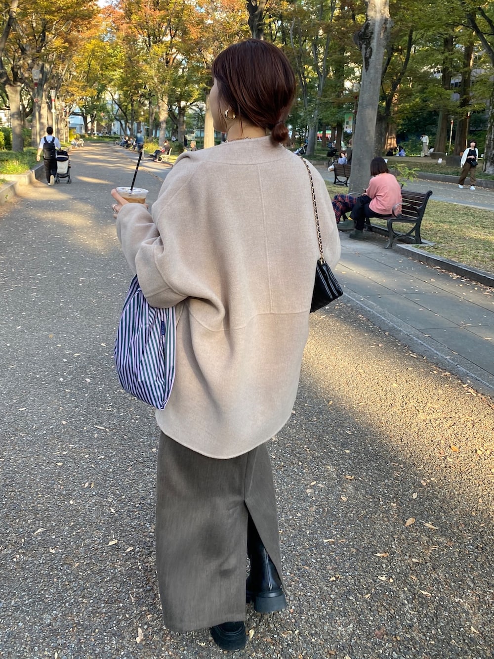 グレー系のニット/セーター、ブラウン系のジャンパースカート、イエロー系のその他アウターを着用したレディースの秋コーディネートの8枚目の写真
