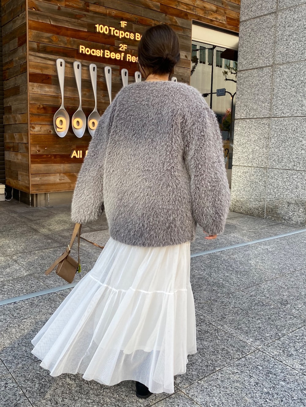 ベージュ系のニット/セーター、ホワイト系のスカート、グレー系のその他アウターを着用したレディースの冬コーディネートの6枚目の写真