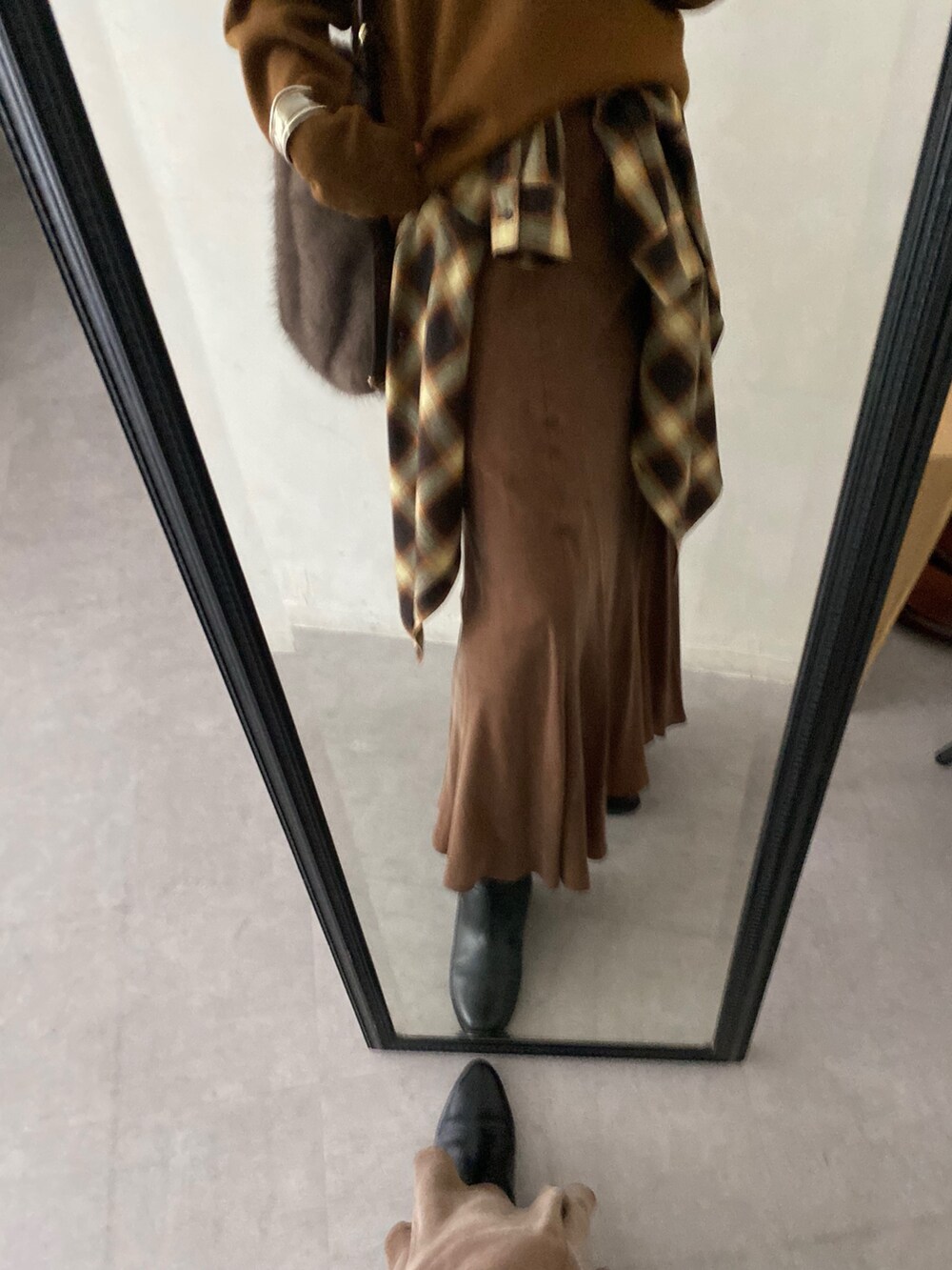 イエロー系のニット/セーター、ブラウン系のスカート、オレンジ系のシャツ/ブラウスを着用したレディースの冬コーディネートの6枚目の写真