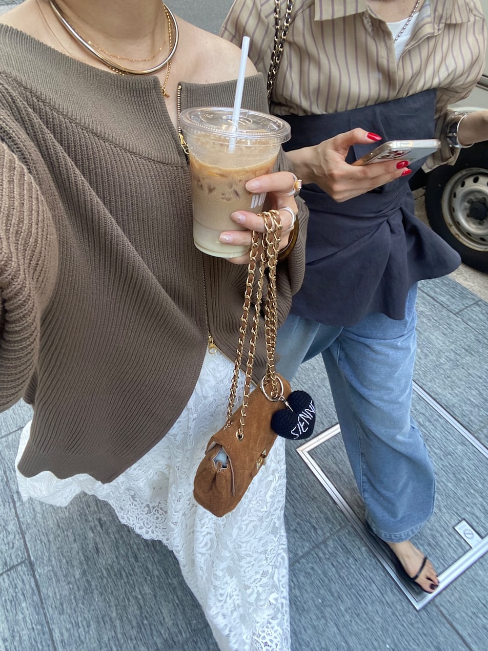 ブラウン系のニット/セーター、イエロー系のショルダーバッグ、ホワイト系のスカートを着用したレディースの秋コーディネートの7枚目の写真