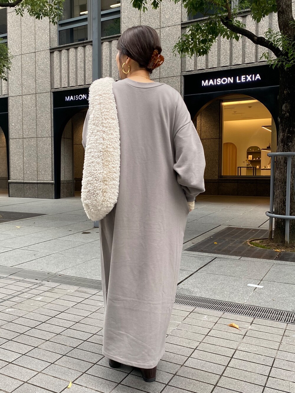 グレー系のワンピース、ブラウン系のブーツ、ゴールド系のTシャツ/カットソーを着用したレディースの秋コーディネートの5枚目の写真
