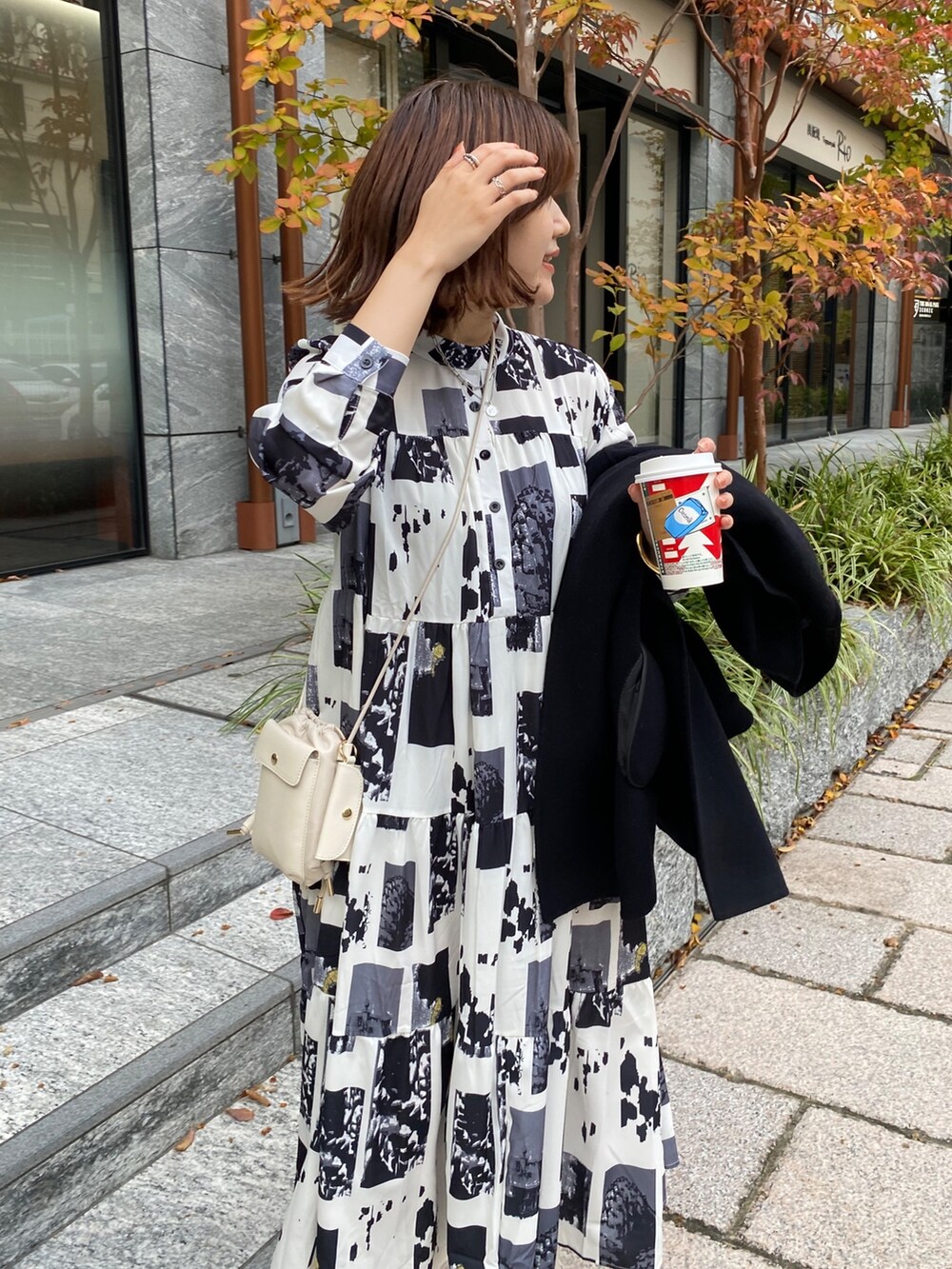 ホワイト系のワンピース、ホワイト系のトートバッグ、ホワイト系のブーツを着用したレディースの秋コーディネートの3枚目の写真