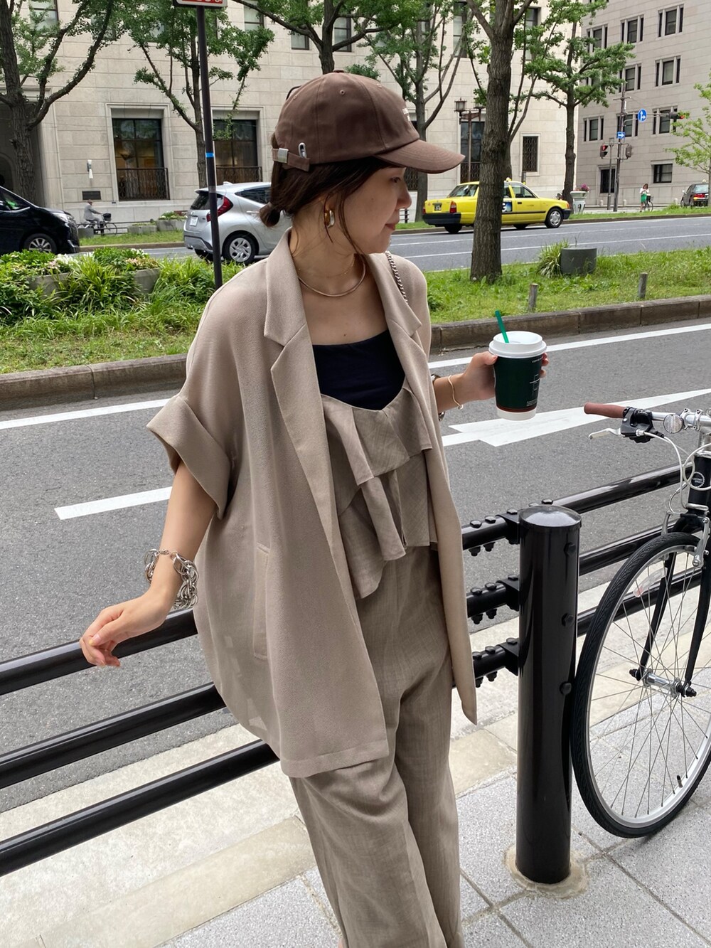 ベージュ系のテーラードジャケット、ベージュ系のつなぎ/オールインワン、ブラウン系のキャップを着用したレディースの夏コーディネートの3枚目の写真