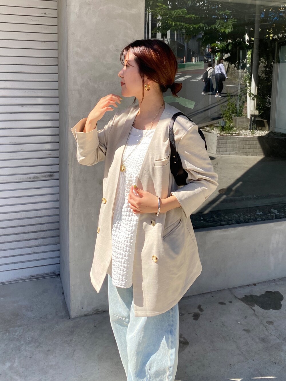 ホワイト系のキャミソール、ブルー系のデニムパンツ、ブラック系のショルダーバッグを着用したレディースの夏コーディネートの6枚目の写真