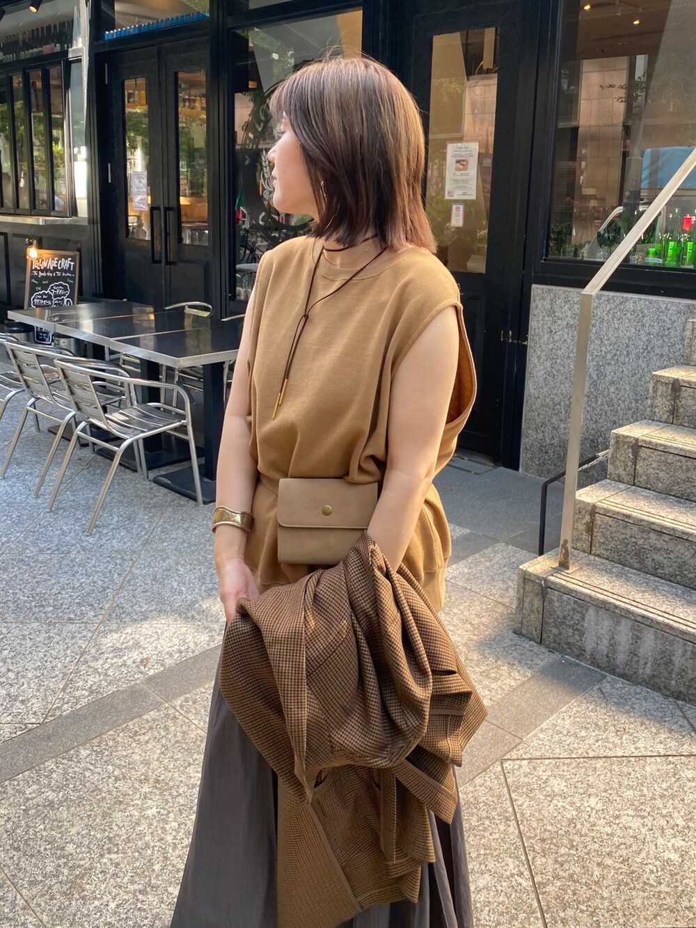 イエロー系のスウェット、グレー系のスカート、ブラウン系のテーラードジャケットを着用したレディースの夏コーディネートの8枚目の写真