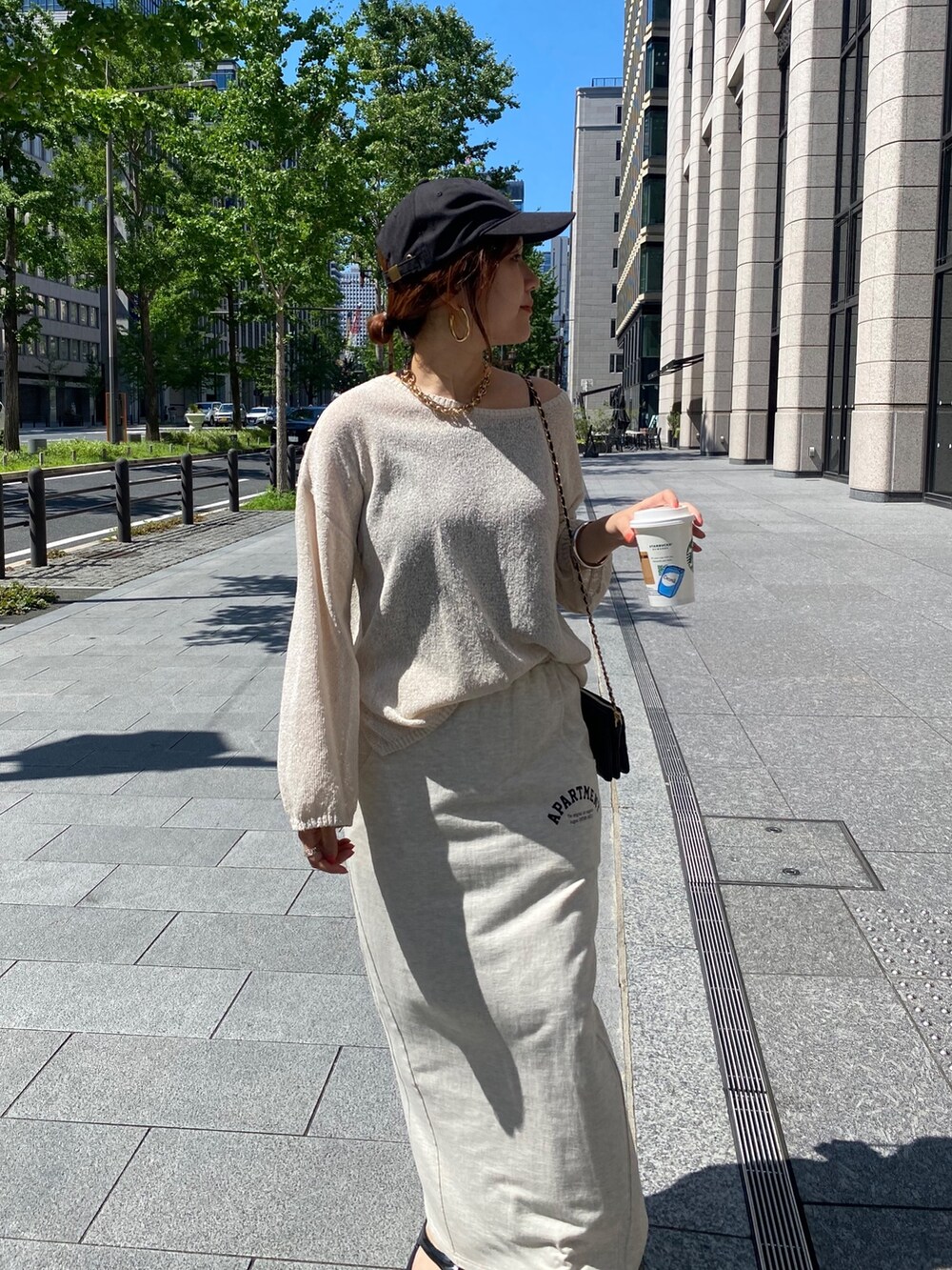 ベージュ系のニット/セーター、ベージュ系のスカート、ブラック系のショルダーバッグを着用したレディースの夏コーディネートの4枚目の写真