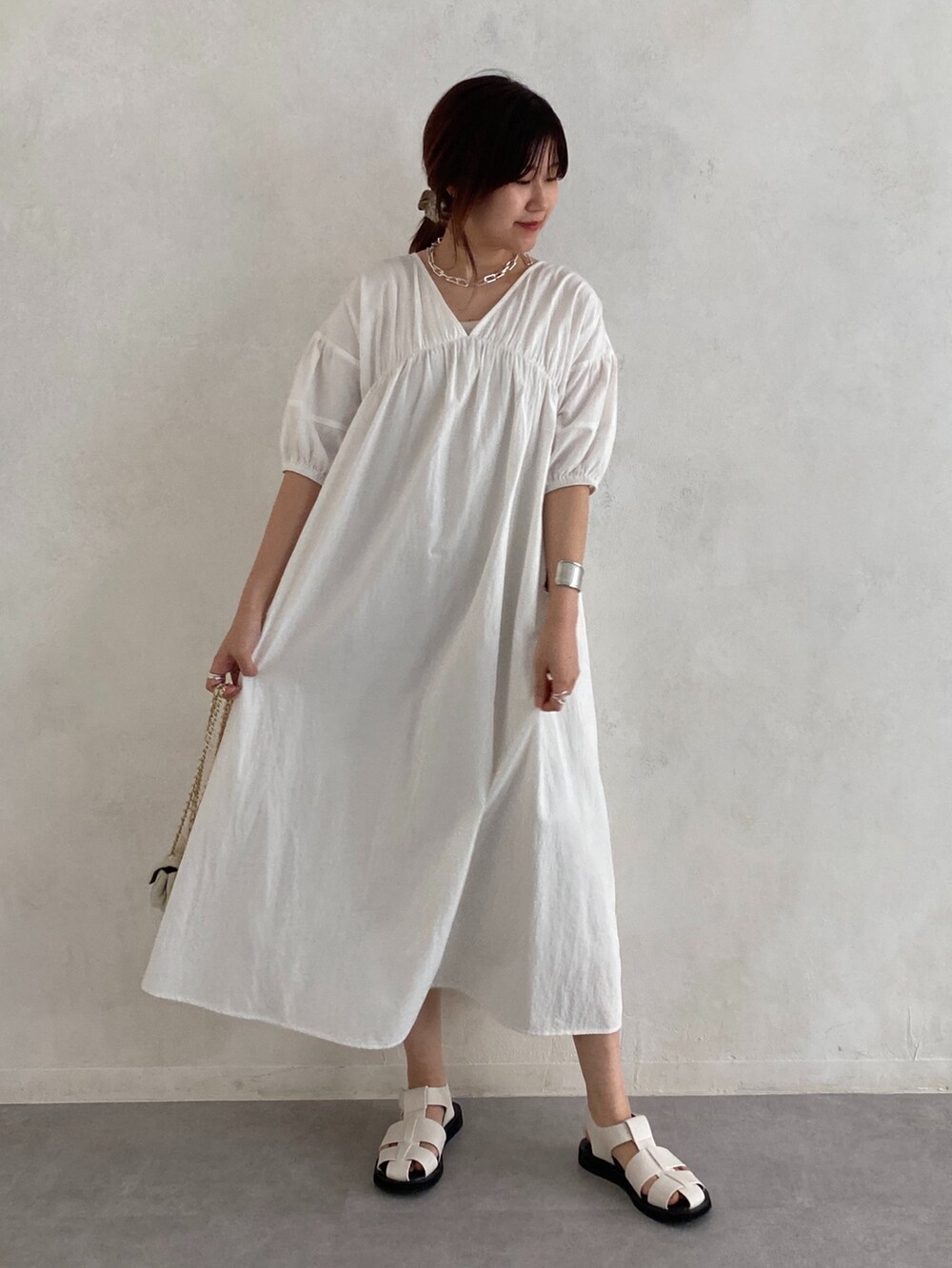 ホワイト系のワンピース、ブラック系のその他シューズ、ホワイト系のショルダーバッグを着用したレディースの夏コーディネートの4枚目の写真