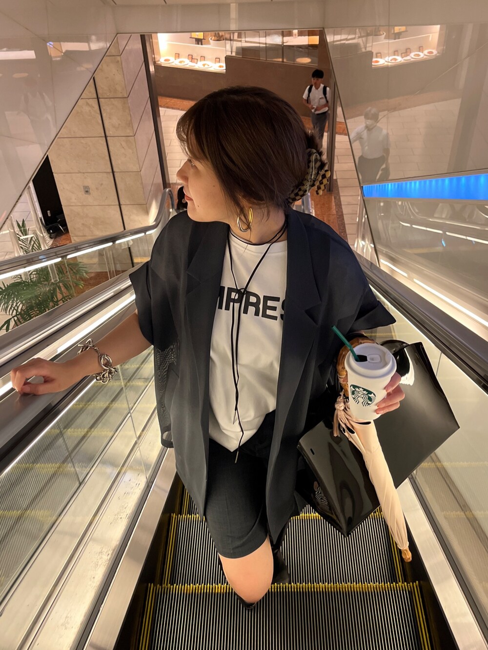 ブラック系のテーラードジャケット、グレー系のその他パンツ、ホワイト系のシャツ/ブラウスを着用したレディースの夏コーディネートの6枚目の写真