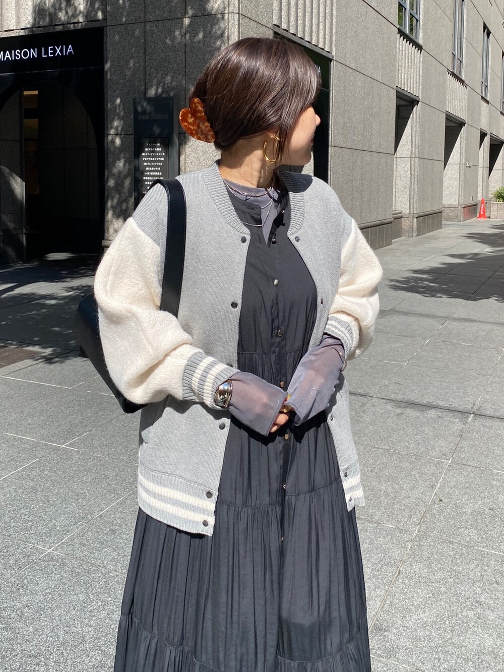 グレー系のその他アウター、ブラック系のワンピース、ブラック系のブーツを着用したレディースの秋コーディネートの4枚目の写真