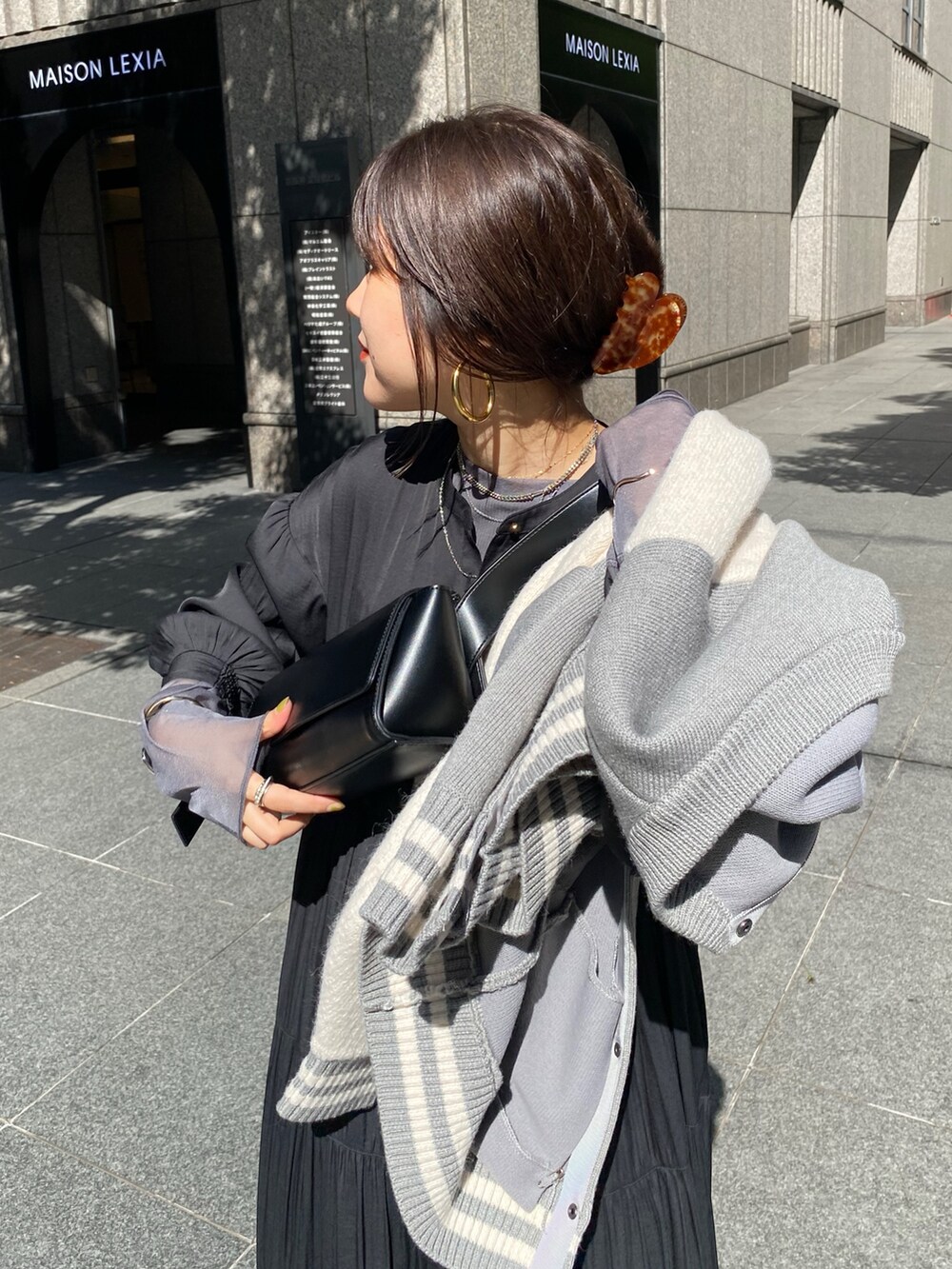 グレー系のその他アウター、ブラック系のワンピース、ブラック系のブーツを着用したレディースの秋コーディネートの7枚目の写真