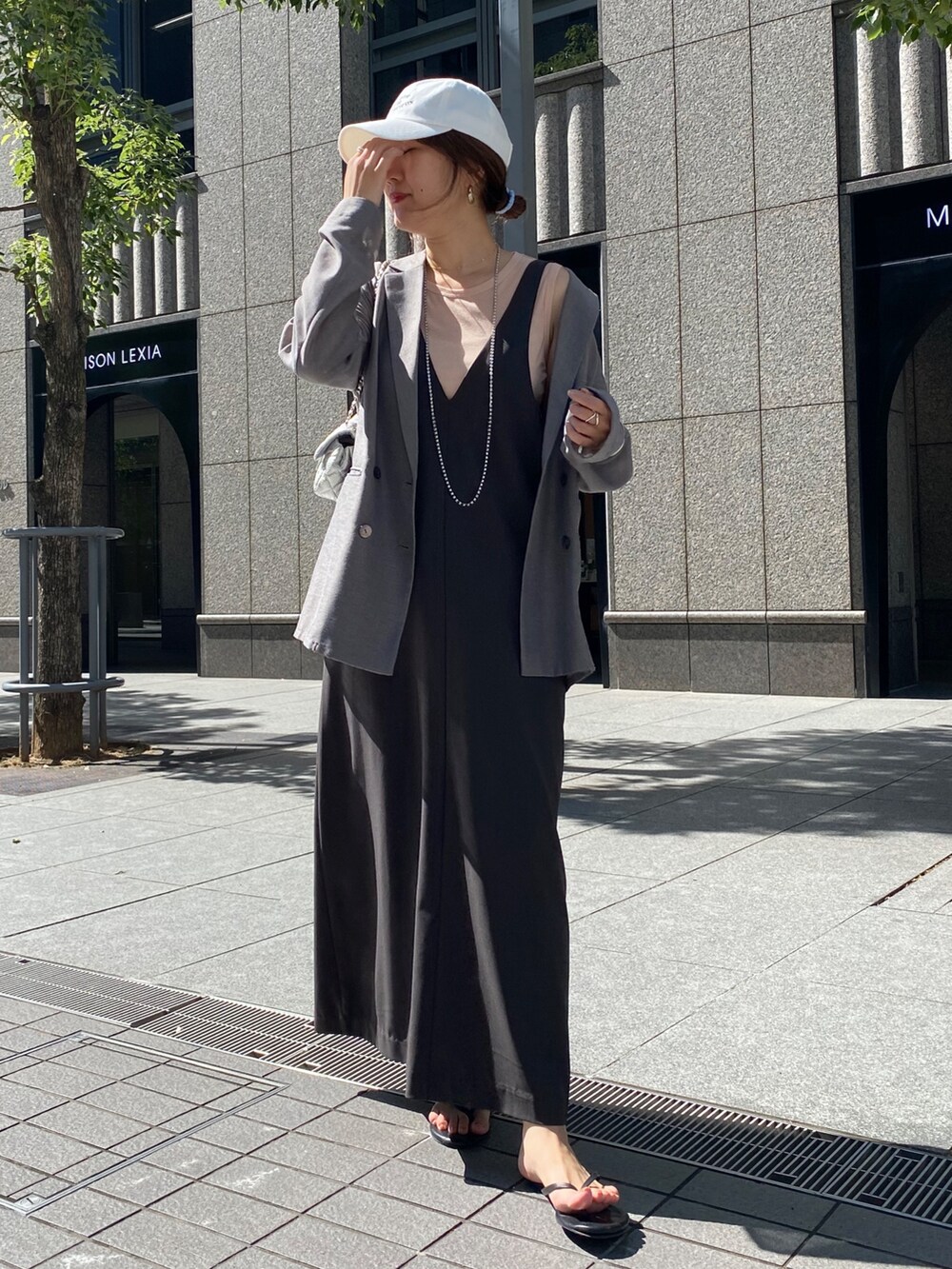 グレー系のワンピース、グレー系のテーラードジャケット、シルバー系のネックレスを着用したレディースの秋コーディネートの10枚目の写真