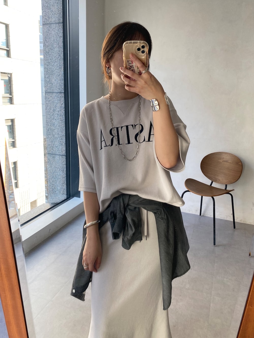 ベージュ系のTシャツ/カットソー、ベージュ系のスカート、ブラック系のシャツ/ブラウスを着用したレディースの冬コーディネートの2枚目の写真