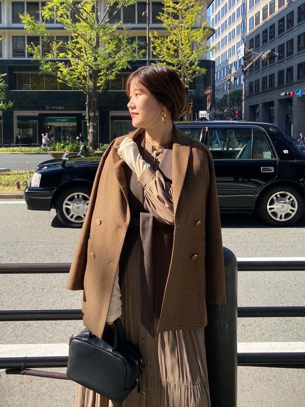 ブラウン系のベスト、ブラウン系のテーラードジャケット、ブラウン系のワンピースを着用したレディースの冬コーディネートの10枚目の写真