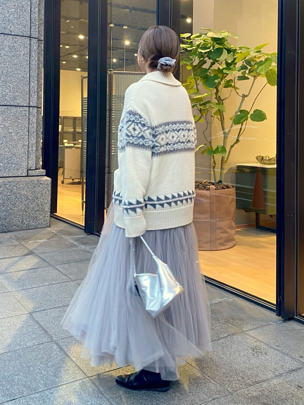 ホワイト系のニット/セーター、グレー系のスカート、シルバー系のショルダーバッグを着用したレディースの冬コーディネートの3枚目の写真