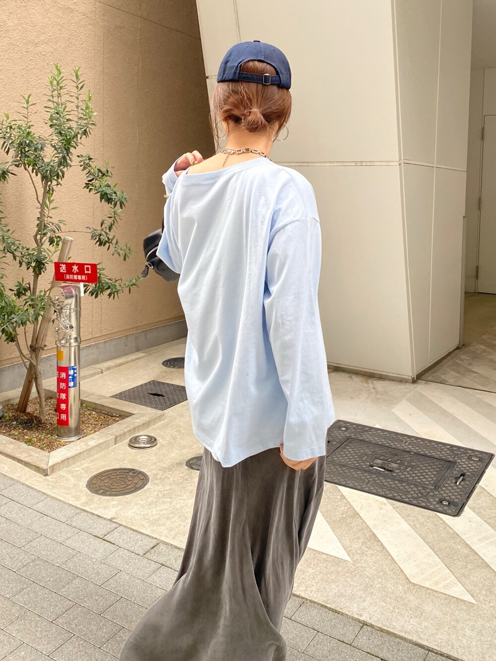 ブルー系のTシャツ/カットソー、ブラック系のスカート、ブラック系のショルダーバッグを着用したレディースの春コーディネートの5枚目の写真