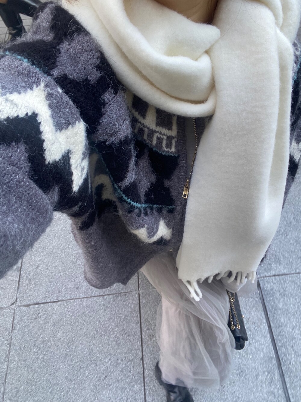 グレー系のカーディガン/ボレロ、ブルー系のTシャツ/カットソー、グレー系のスカートを着用したレディースの冬コーディネートの6枚目の写真