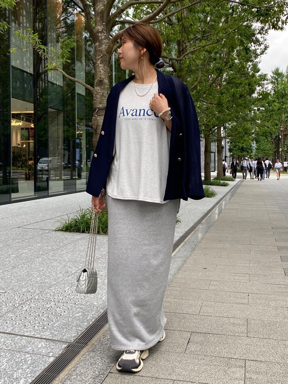 ベージュ系のテーラードジャケット、グレー系のTシャツ/カットソー、シルバー系のスカートを着用したレディースの夏コーディネートの8枚目の写真